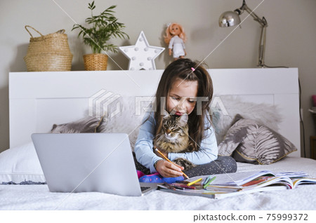 Distance learning online education. Schoolgirl with digital tablet laptop notebook and doing school 75999372