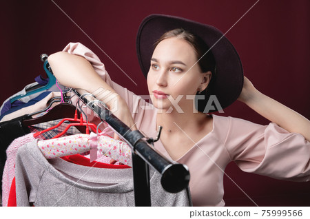 young girl in a hat chooses clothes young girl in a hat chooses clothes 75999566