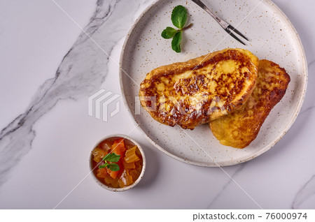 Homemade traditional Spanish torrijas or French toast with melon candied fruit and mint 76000974