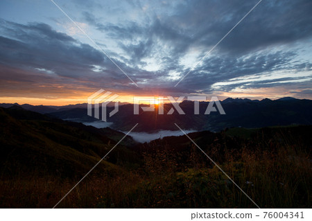 Early morning in the mountains. The sun rises over the mountains. Dawn in the mountains. 76004341