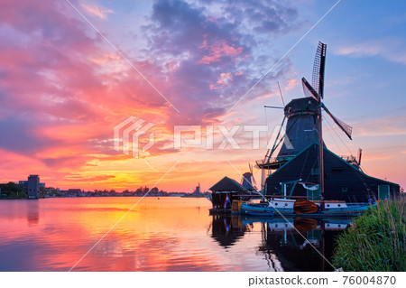 Windmills at Zaanse Schans in Holland on sunset. Zaandam, Nether Windmills at Zaanse Schans in Holland on sunset. Zaandam, Nether 76004870