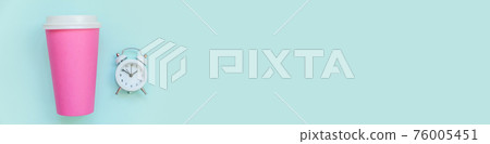 Simply flat lay design pink paper coffee cup and alarm clock isolated on blue pastel background. Takeaway drink breakfast beverage. Good morning wake up awake concept. Top view copy space, banner 76005451