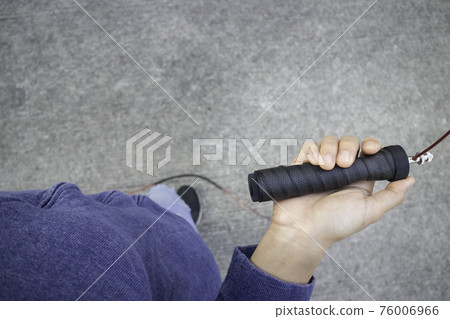 Hand of woman holding a speed jump rope Hand of woman holding a speed jump rope 76006966