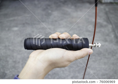 Hand of woman holding a speed jump rope 76006969