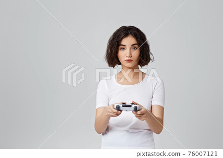 girl playing video games on gray background 76007121