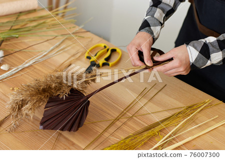 florist makes beautiful bouquet of dried flowers florist makes beautiful bouquet of dried flowers 76007300