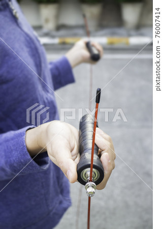 Hand of woman holding a speed jump rope Hand of woman holding a speed jump rope 76007414