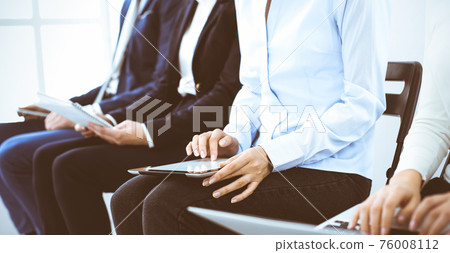 Group of business people working in office, close-up. Businesswoman typing on laptop. Conference, training or meeting concepts Group of business people working in office, close-up. Businesswoman typing on laptop. Conference, training or meeting concepts 76008112