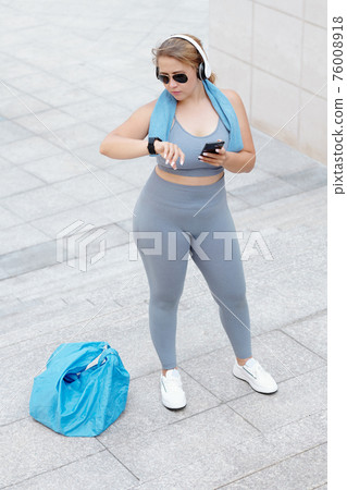 Fit woman checking trekker 76008918