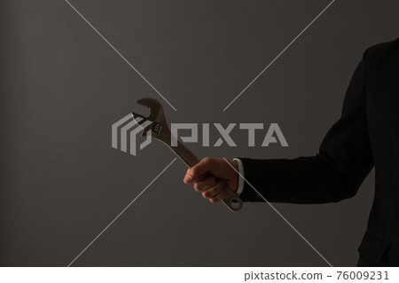 Men's suit with a wrench at hand 76009231