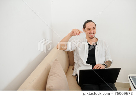 Man working on laptop at home Man working on laptop at home 76009678