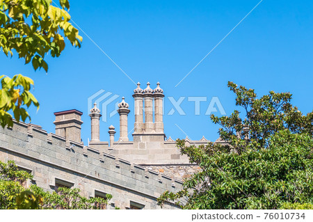 The walls and towers of the old palace on the background of a blue sky 76010734