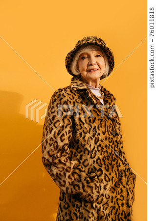 Woman looking a the camera while keeping hands in her pockets 76011818