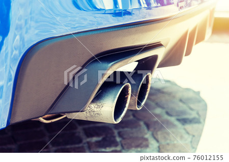 Close up of a car dual exhaust pipe in sunlight 76012155