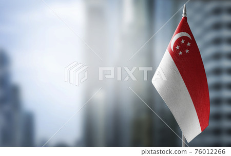 A small flag of Singapore on the background of a blurred background 76012266