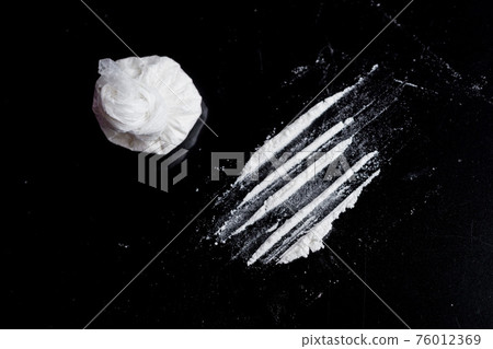 white powder (heroin, cocaine, narcotic) in a plastic bag on a black background, drugs are scattered in the form of a track white powder (heroin, cocaine, narcotic) in a plastic bag on a black background, drugs are scattered in the form of a track 76012369