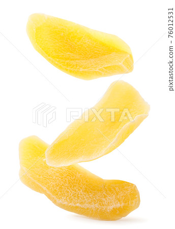 Dried mango slices falling on a white background. Isolated Dried mango slices falling on a white background. Isolated 76012531