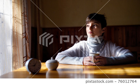 Poor sad small girl sitting at the table indoors at home, poverty concept. Poor sad small girl sitting at the table indoors at home, poverty concept. 76012764