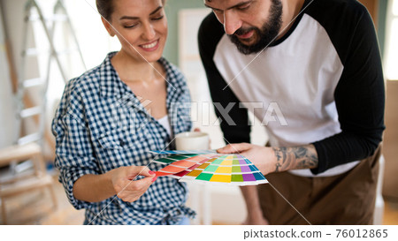 Mid adults couple with colour swatch indoors at home, relocation and diy concept. 76012865