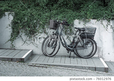 Bicycles parked on the sidewalk in a german tourist location on Rugen island Bicycles parked on the sidewalk in a german tourist location on Rugen island 76012976