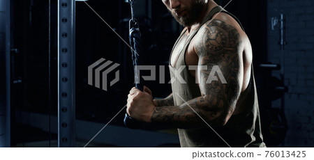 Incognito bodybuilder doing crossover exercise. Incognito bodybuilder doing crossover exercise. 76013425