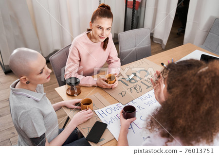 Girls sitting with cup of tea and preparing to the future rally Girls sitting with cup of tea and preparing to the future rally 76013751