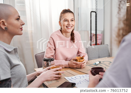 Girls spending time together at the cup of tea at the office Girls spending time together at the cup of tea at the office 76013752