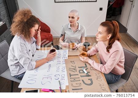 Girl drinking tea and talking about women's rights with her girlfriends Girl drinking tea and talking about women's rights with her girlfriends 76013754