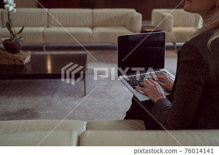 Hard-working woman using her laptop to work distantly during a layover Hard-working woman using her laptop to work distantly during a layover 76014141