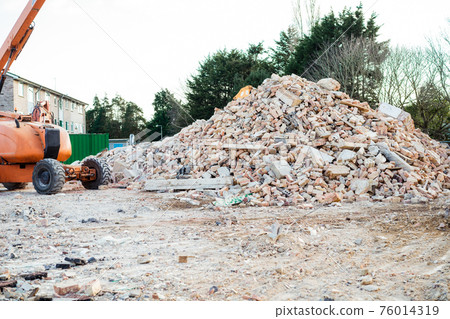 Excavator removes construction waste after building demolition. Building rubble, bricks, stones. Junk, Garbage piled up. Street scene. Recycling industry, rubbish removal, and collection service. Excavator removes construction waste after building demolition. Building rubble, bricks, stones. Junk, Garbage piled up. Street scene. Recycling industry, rubbish removal, and collection service. 76014319
