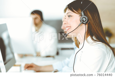 Group of diverse operators at work in call center. Beautiful asian woman sitting in headset at customer service office. Business concept 76014440