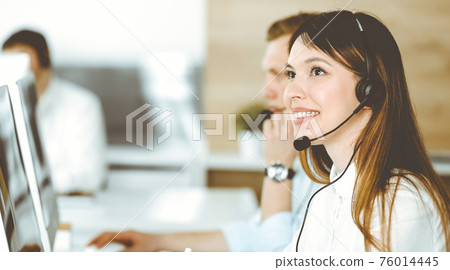 Group of diverse operators at work in call center. Beautiful asian woman sitting in headset at customer service office. Business concept Group of diverse operators at work in call center. Beautiful asian woman sitting in headset at customer service office. Business concept 76014445