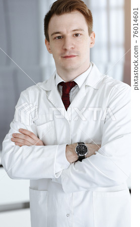 Doctor man headshot while standing in hospital office. Physician at workplace, portrait photo. Medicine and health care concept 76014601
