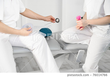 Team of physiotherapists practicing exercises for helping patients Team of physiotherapists practicing exercises for helping patients 76014766