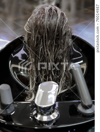 wet client's hair in a barbershop with detergent applied to them 76014987