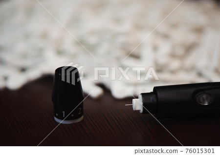 Diabetes pen injection needle. Lancets for an insulin pen on a wooden backgraund. 76015301