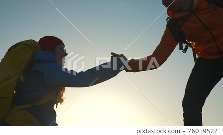 teamwork. help business travel silhouette concept. group team of tourists lends helping hand climb the cliffs mountains. teamwork people climbers climb adventure to top helping hand hardships path teamwork. help business travel silhouette concept. group team of tourists lends helping hand climb the cliffs mountains. teamwork people climbers climb adventure to top helping hand hardships path 76019522