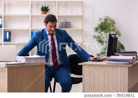 Young male employee in multitasking concept 76019651