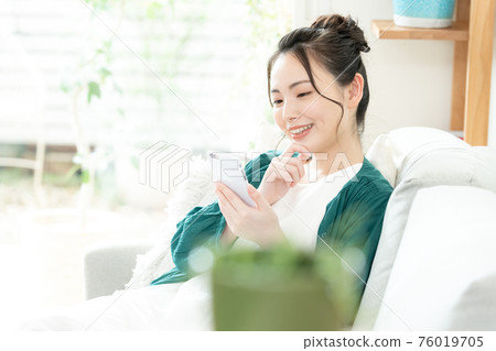 Young woman looking at a smartphone 76019705