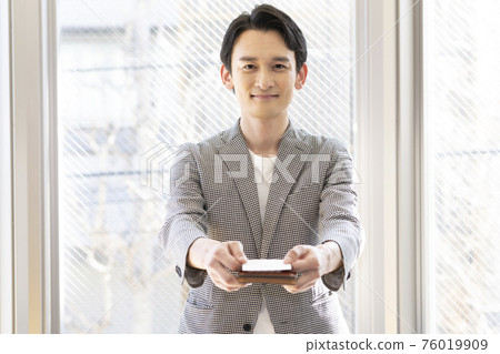 Man presenting a business card (front) 76019909