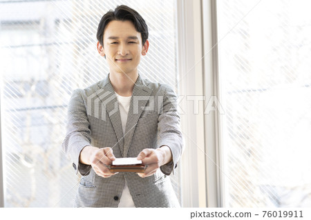 Man presenting a business card (front) 76019911