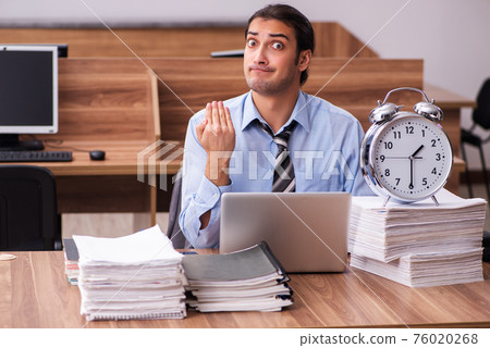 Young male employee in time management concept Young male employee in time management concept 76020268