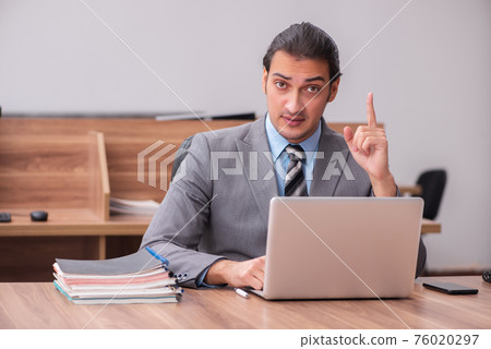 Young male employee working in the office Young male employee working in the office 76020297