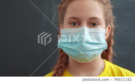 kid face in medical mask. pandemic coronavirus medicine concept. portrait of a face covid girl kid child in a protective mask into the coronavirus pandemic covid. Coronavirus protection kid face in medical mask. pandemic coronavirus medicine concept. portrait of a face covid girl kid child in a protective mask into the coronavirus pandemic covid. Coronavirus protection 76021182