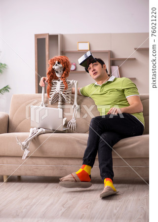 Young man with female skeleton in virtual reality concept Young man with female skeleton in virtual reality concept 76021220