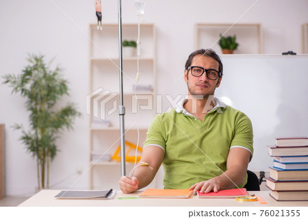Young sick male teacher student in blood transfusion concept 76021355