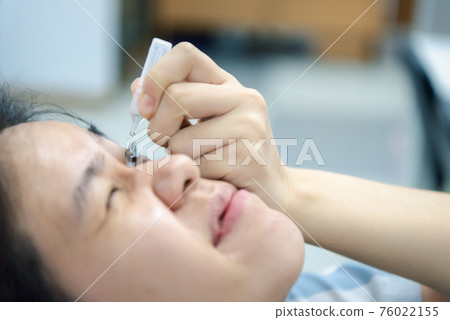 Woman use eye drop, artificial tears to the eye Woman use eye drop, artificial tears to the eye 76022155