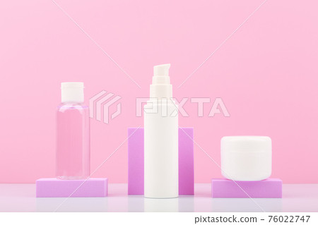 Cosmetic set with lotion, face cream and under eye cream on podiums against bright pink background.  76022747