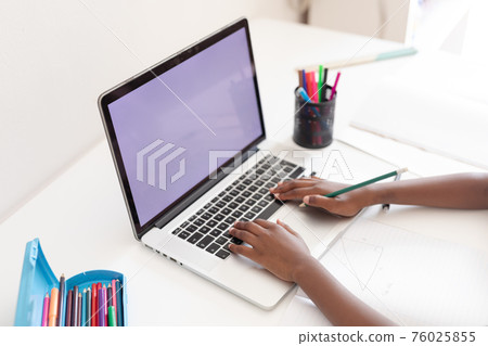 Hands of african american girl at desk using laptop with copy space for online school lesson Hands of african american girl at desk using laptop with copy space for online school lesson 76025855