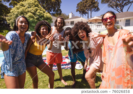 Diverse group of friends having fun and smiling at a pool party 76026858